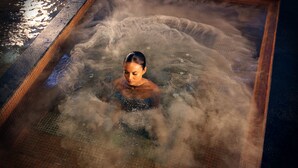 A person in a hot tub with a tiled interior and a small flower arrangement on the edge. - The Fives Beach Hotel - Á la Carte All Inclusive (Playa del Carmen)