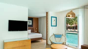 Een hotelkamer met een bed, een televisie, een houten dressoir, een stoel bij het raam en uitzicht op een zwembad.