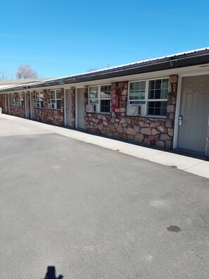 A motel with stone exterior walls, multiple windows, and a 'No Smoking' sign. - Rodeway Inn La Grande - Island City (La Grande)