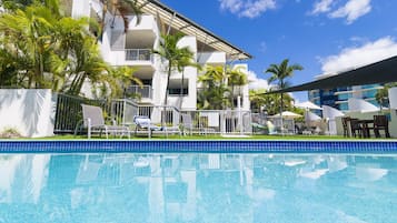 Una piscina al aire libre, sombrillas