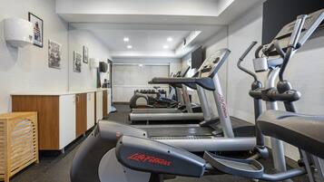 A gym with treadmills, stationary bikes, and a weight bench.