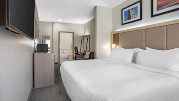 A hotel room with a large bed, a television, a desk, and a bathroom.