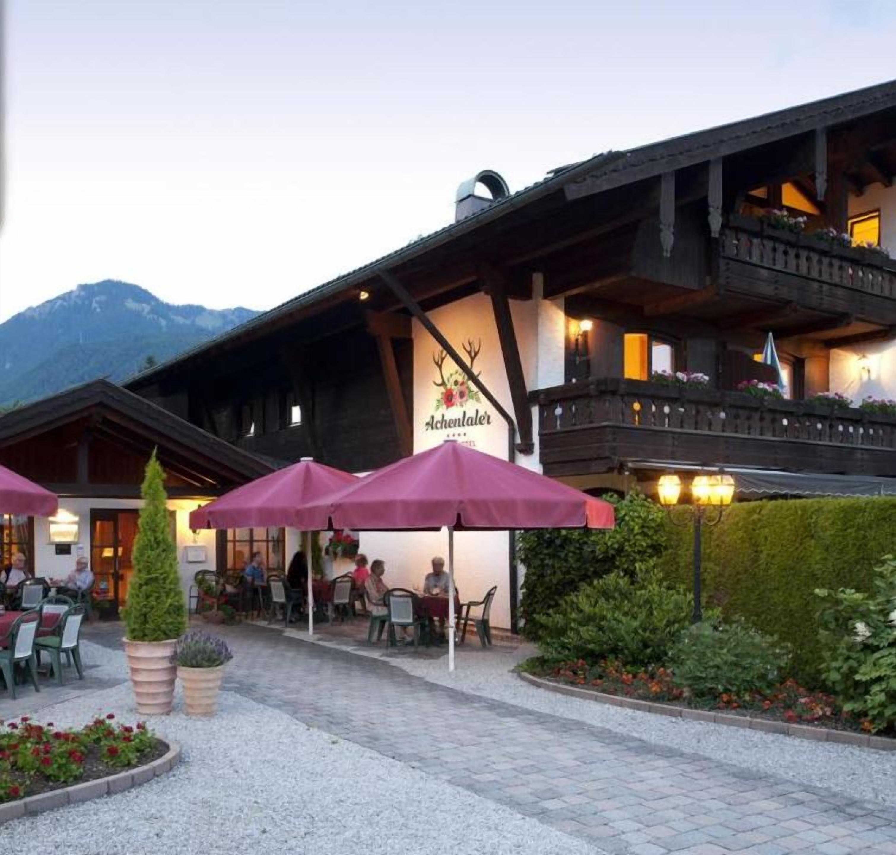 A hotel with outdoor seating and a mountain backdrop.