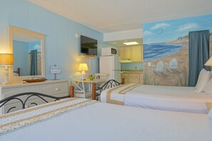 A hotel room with two beds, a desk, a chair, a television, and a kitchen area. - The Crossings (Ocean City)