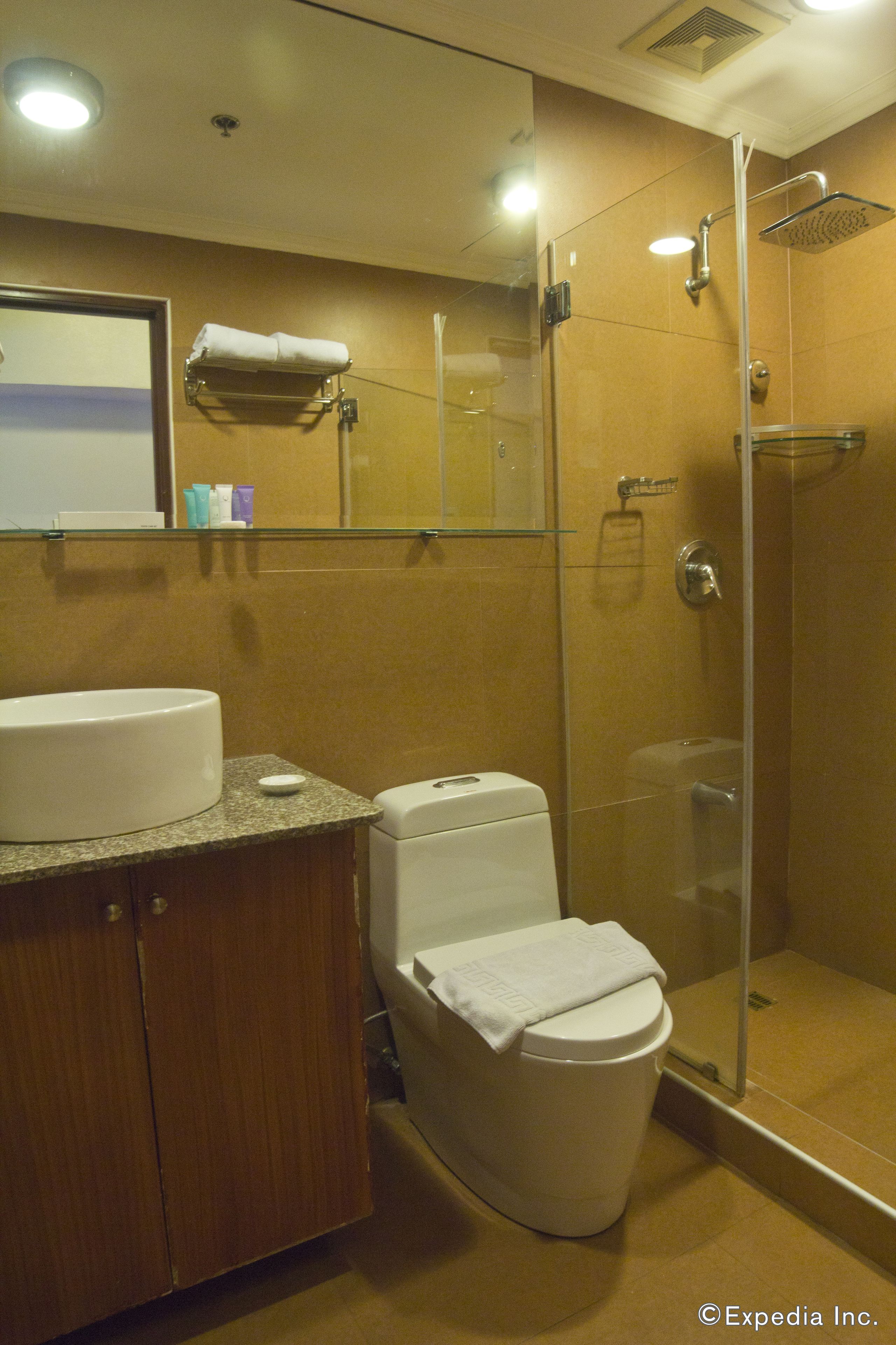 A bathroom with a sink, toilet, and glass-enclosed shower.