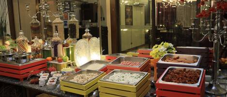 A buffet setup with various food items and decorative elements.