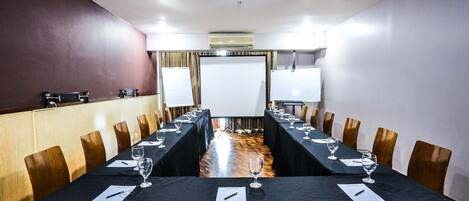 A conference room with a long table, chairs, and a whiteboard.
