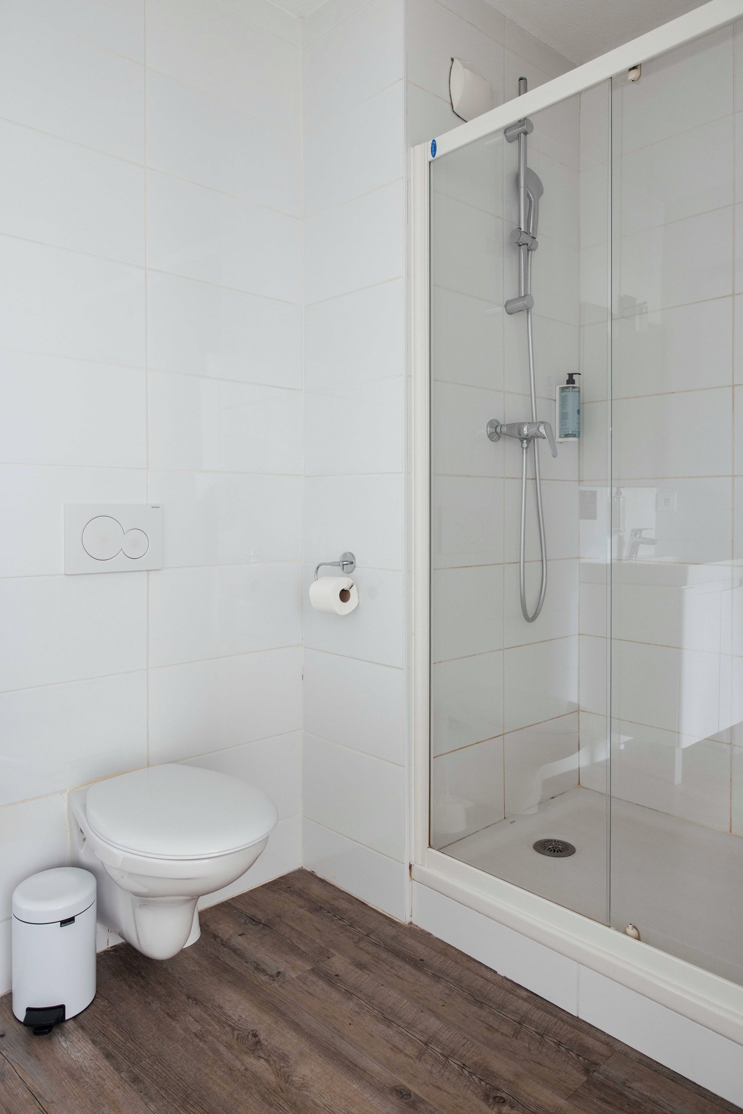 Un baño moderno con cabina de ducha de vidrio, inodoro y bidé.