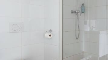 Un baño moderno con cabina de ducha de vidrio, inodoro y bidé.