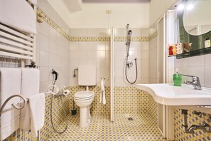A bathroom with a toilet, shower, and sink, featuring checkered floor tiles and a towel rack. - Locanda de' Ciompi (Florence)