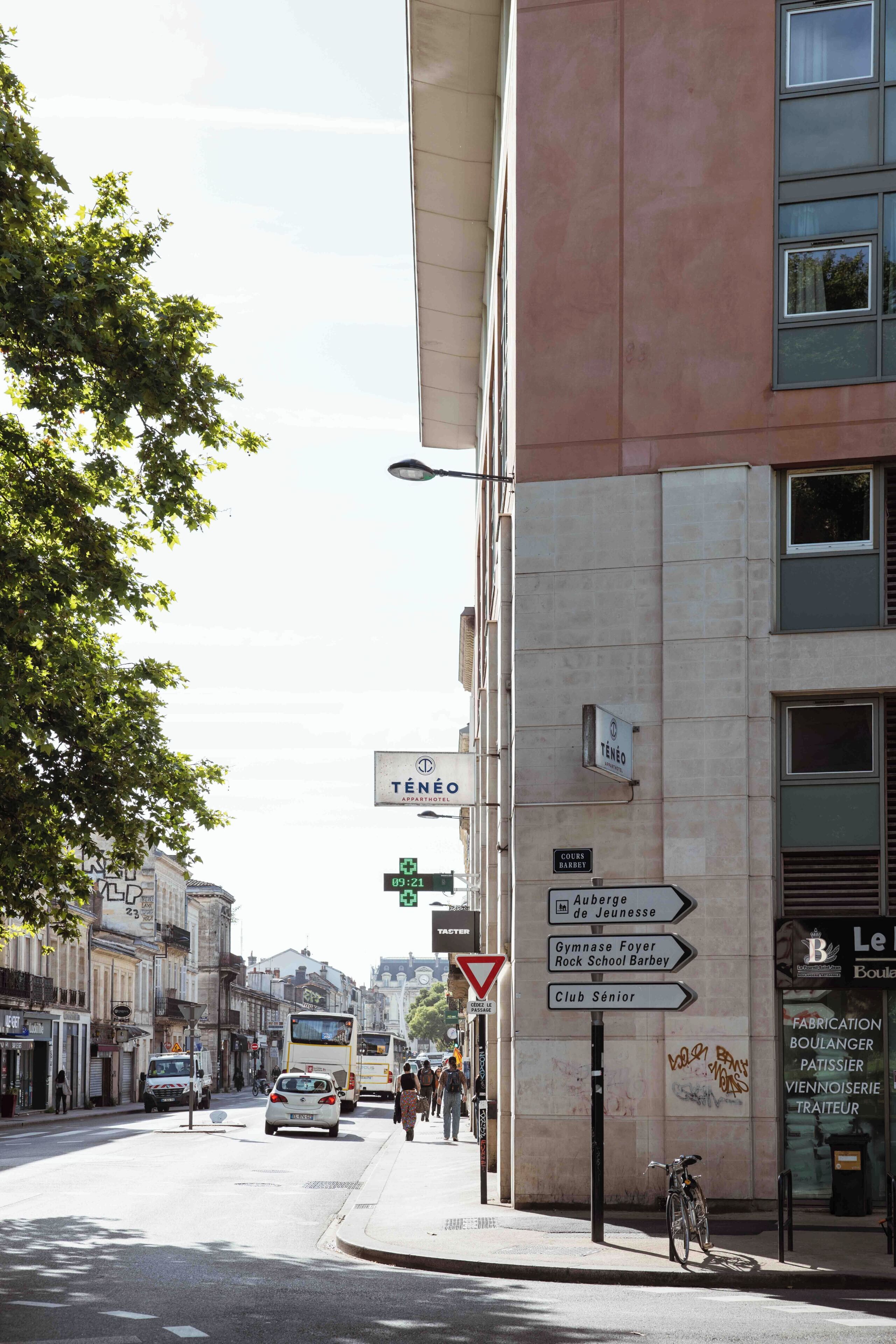 Une vue de rue avec un bâtiment sur lequel on peut voir une enseigne indiquant « Ténéo » et « Le Boulanger ».
