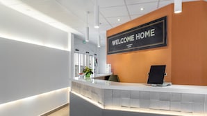 A reception area with a 'WELCOME HOME' sign, a reception desk, and a plant. - Le Club Mougins (Mougins)