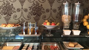 A buffet area with various food items, including pastries, fruits, and condiments. - Hôtel Le Patio de Violette (Uzès)