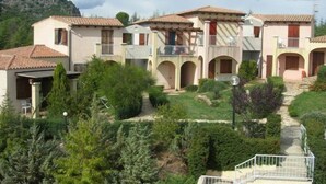 Un edificio de varios pisos con un patio central, con balcones y paseos con arcos.