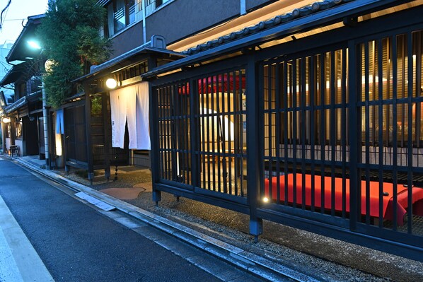 Un edificio japonés tradicional con un corredor cubierto y una banca roja.