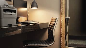 A modern office desk with a computer, a lamp, and a chair.