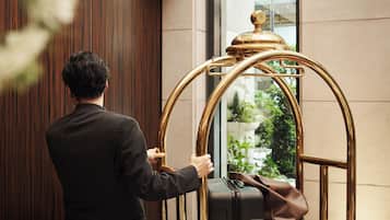 A person in a black suit interacting with a golden, ornate elevator door.