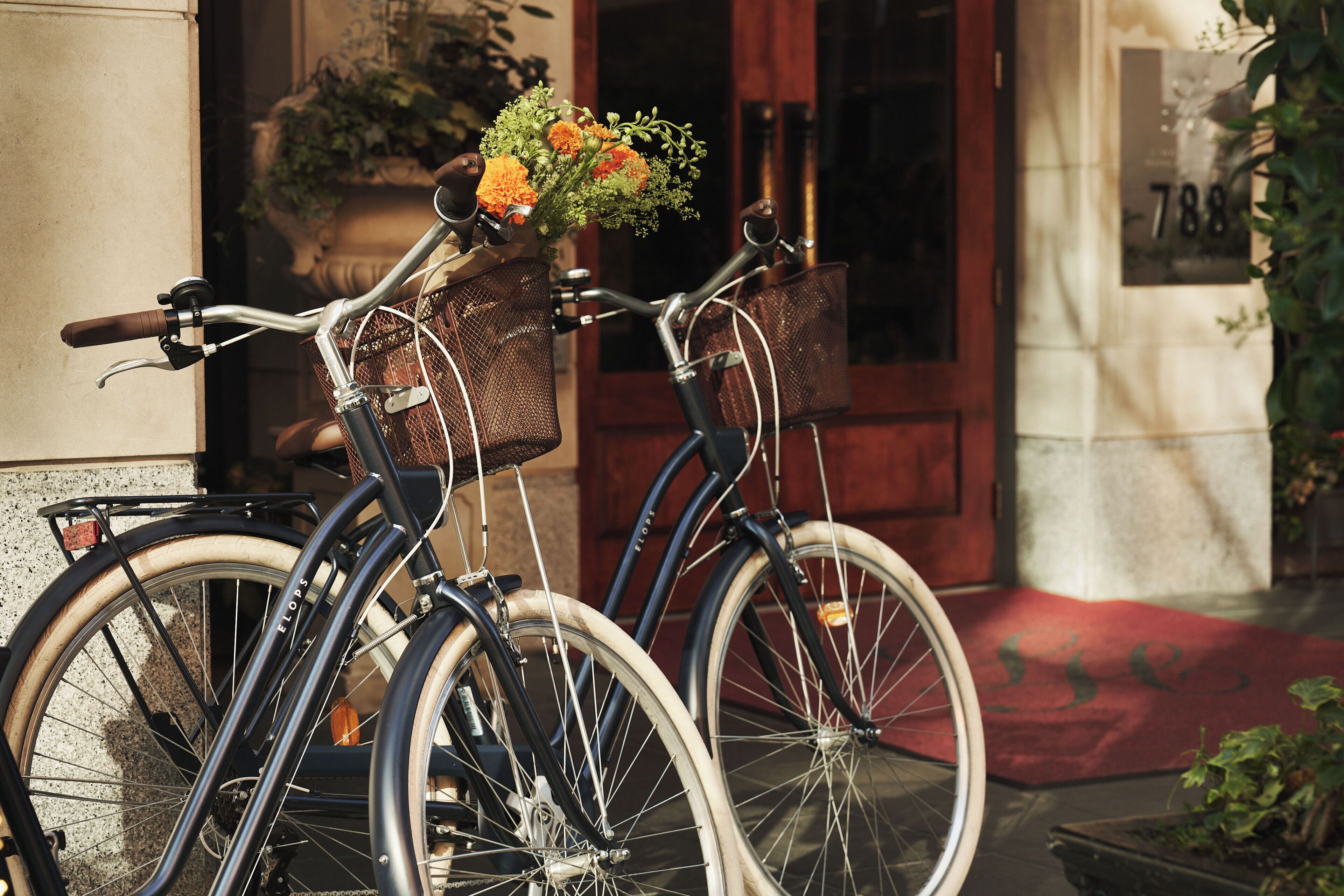 Two bicycles parked outside a building with a number '788' visible on the wall.