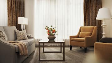 Una sala de estar con sofá, sillón, mesa de centro y lámparas.