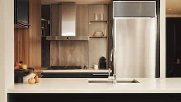 A modern kitchen with a stainless steel refrigerator, a built-in oven, and a sink.