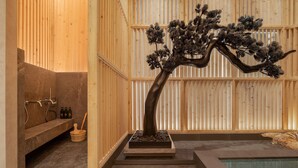 A spa area with a wooden wall, a stone bench, a small pool, and a bonsai tree. - Le Meridien Bangkok (Bangkok)