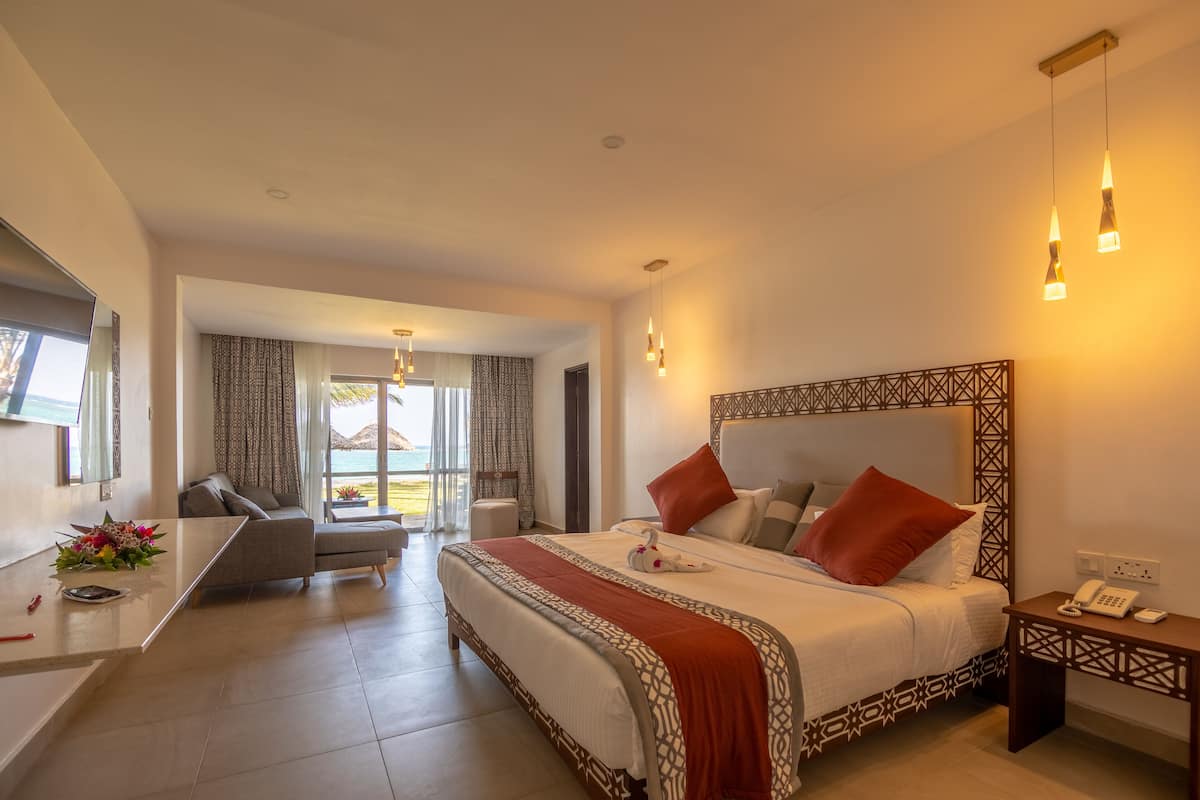 Ein Hotelzimmer mit einem großen Bett, einem Schreibtisch und Blick ins Freie.