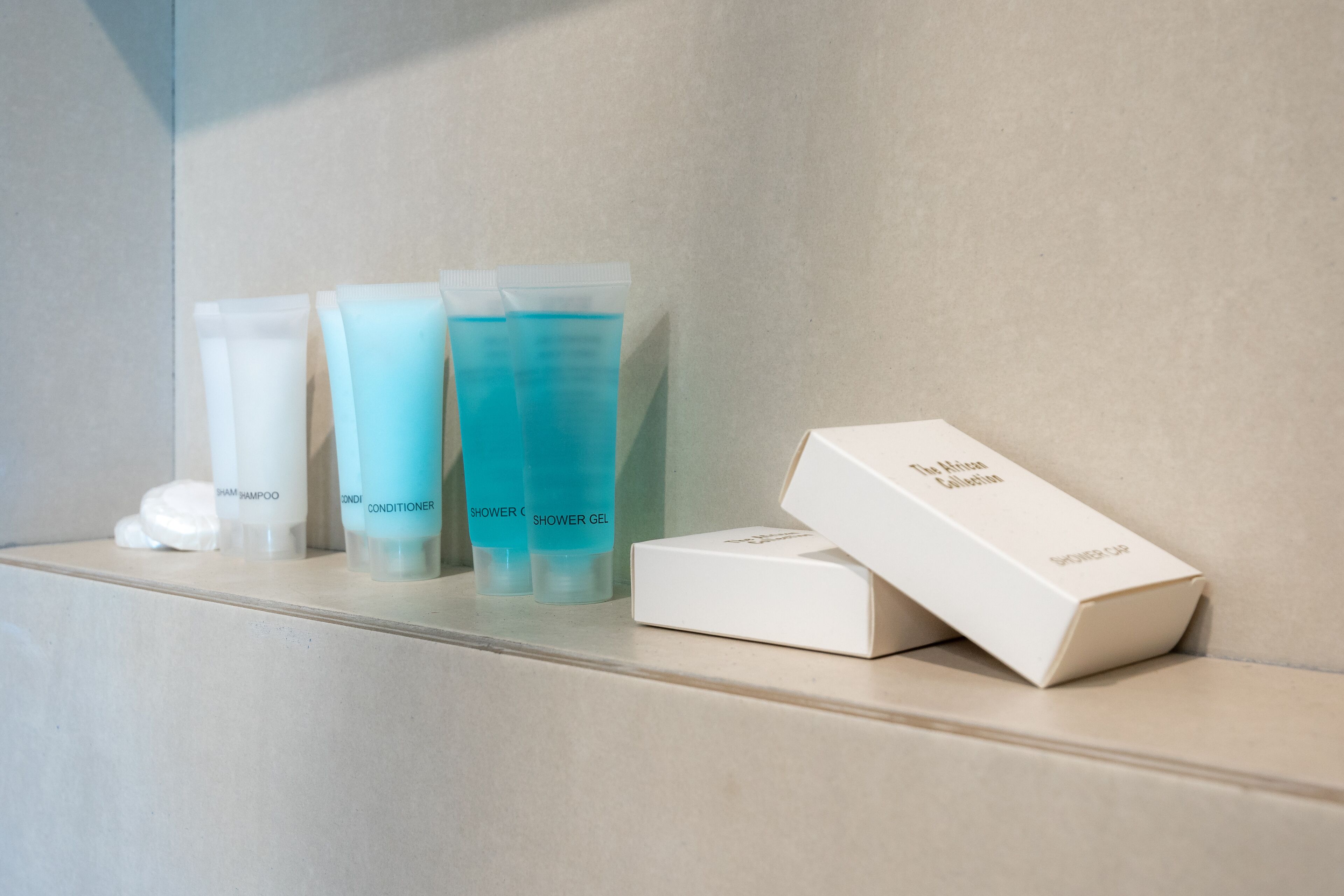 Un estante de baño con diversos artículos de aseo, como champú, acondicionador y gel de ducha.