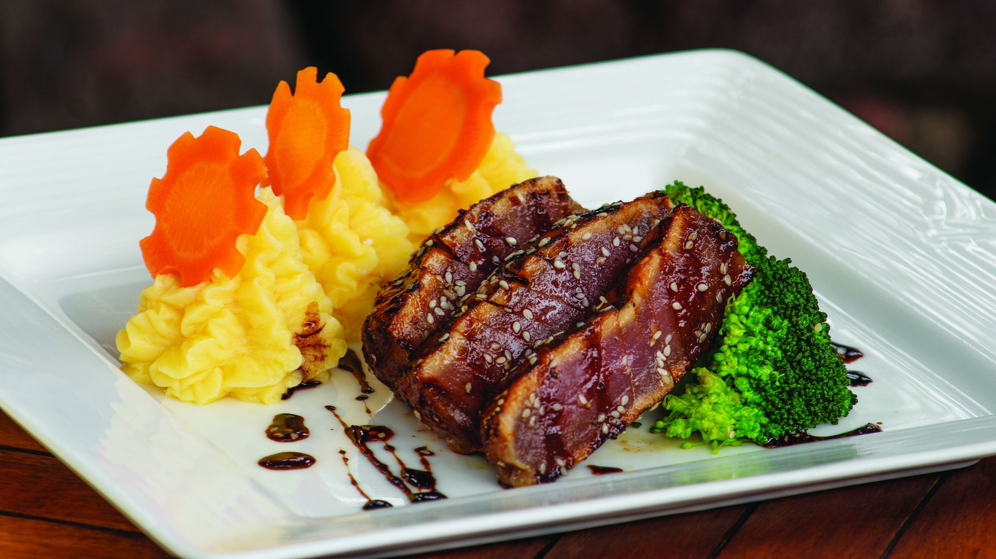 A plate with a piece of meat, mashed potatoes, and broccoli.