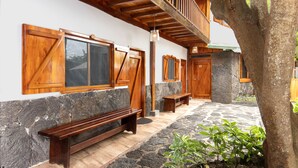 Un banco de madera, un muro de piedra y una puerta de madera con el número 12.