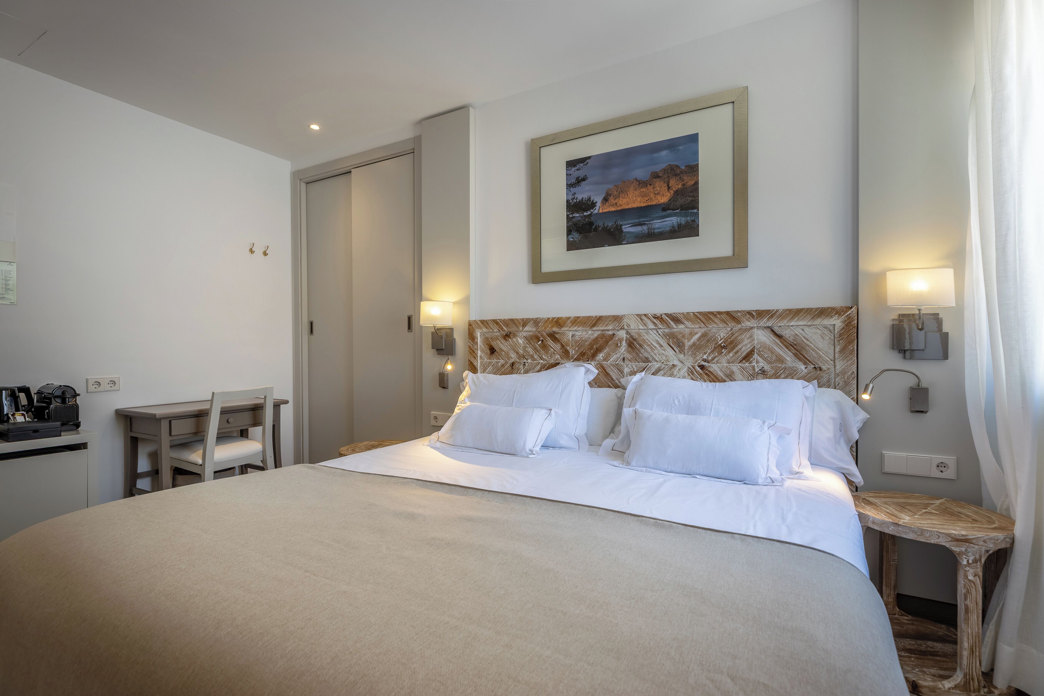 Une chambre d’hôtel avec un lit, un bureau et une chaise.