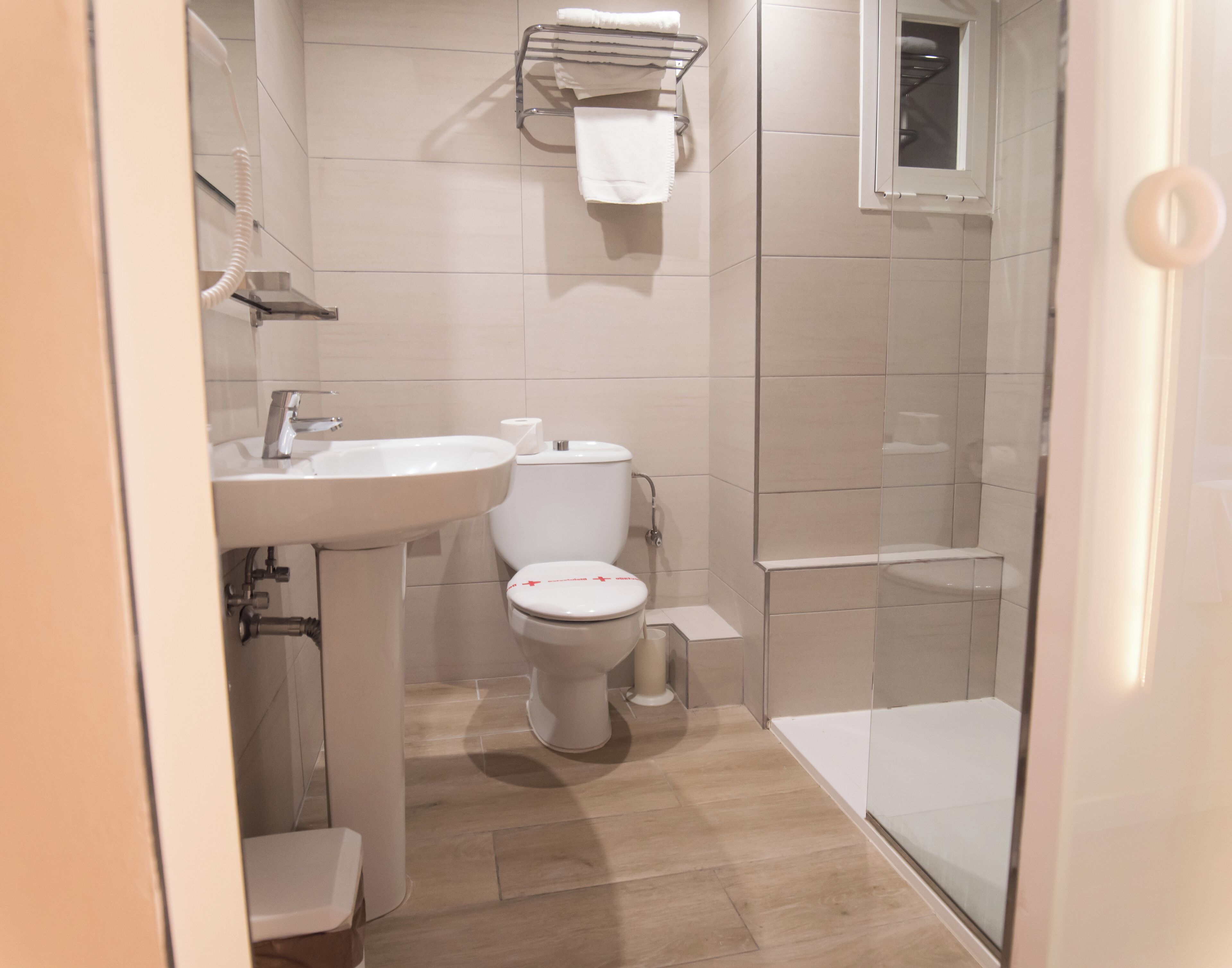 Un baño con lavamanos, inodoro y ducha.