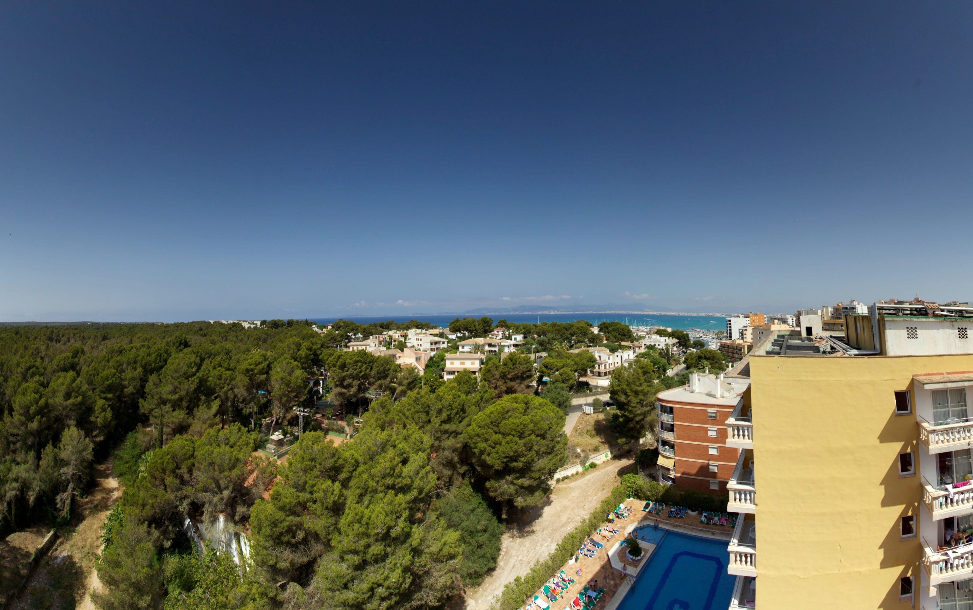 Zona residencial con piscina, árboles y edificios.