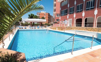Una piscina al aire libre, tumbonas