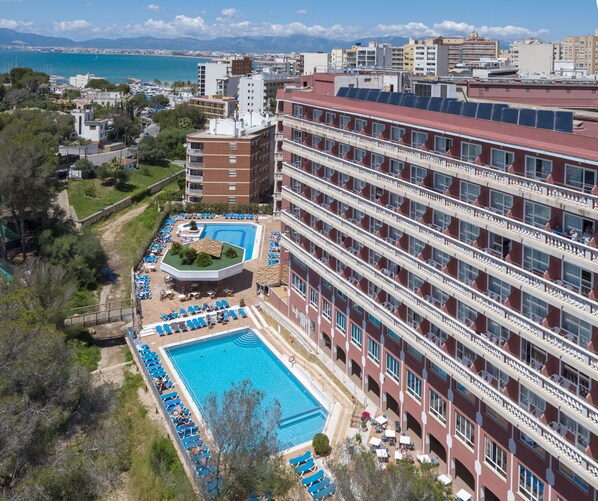 Un hôtel de grande hauteur doté d’une piscine sur le toit, de nombreux balcons et offrant une vue sur la mer.