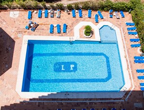 Una piscina al aire libre, tumbonas