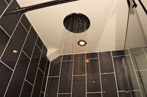 A shower with a circular drain and water falling into it. - Hickman Hill Hotel (Gainsborough)