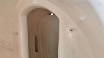 A small, enclosed space with a curved ceiling and a single door.