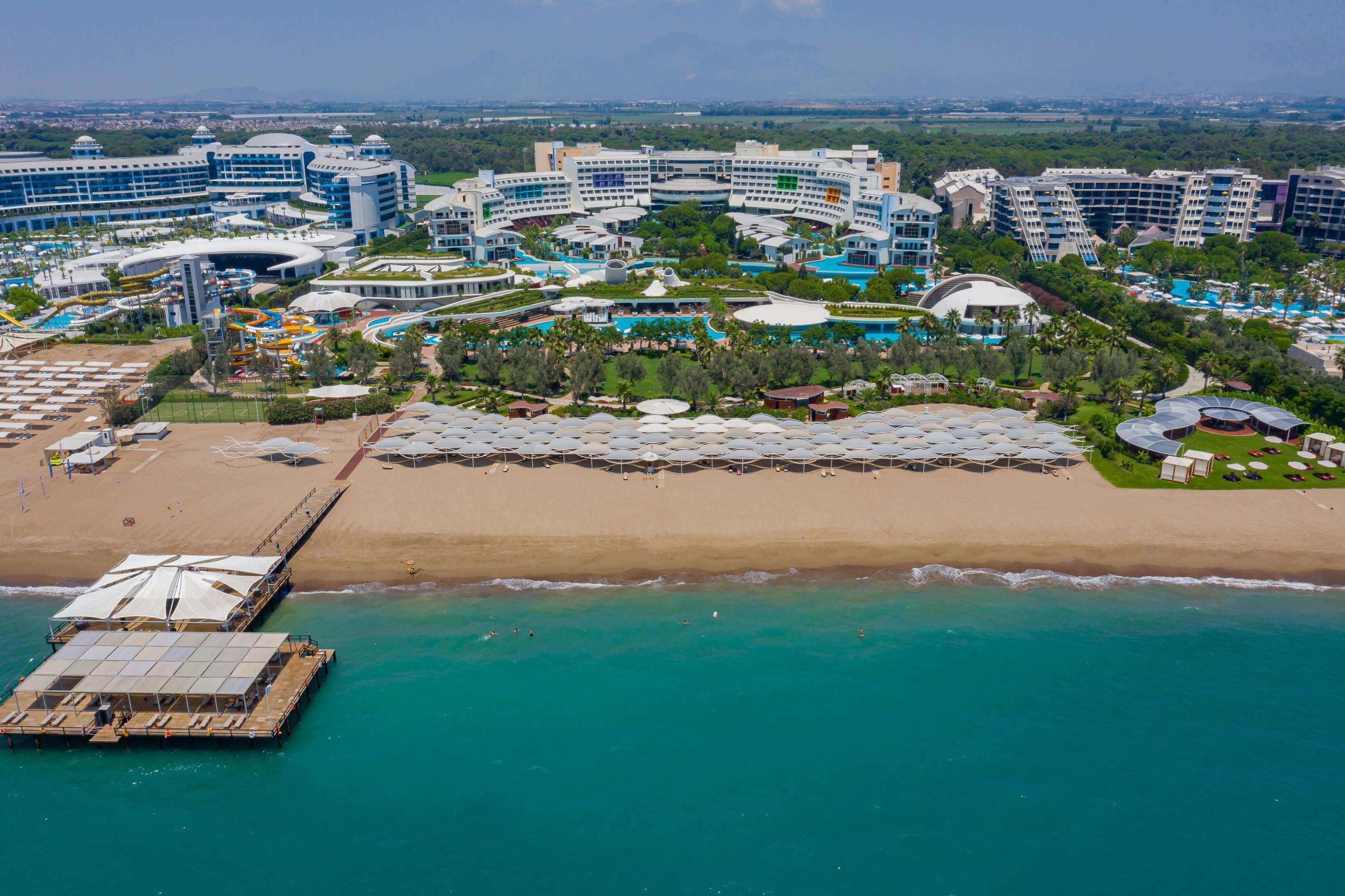 An aerial view of a resort with multiple buildings, a beach, and a water park.