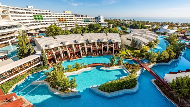 A resort with multiple swimming pools, a large building with balconies, and lush greenery. - Cornelia Diamond Golf Resort & SPA (Serik)