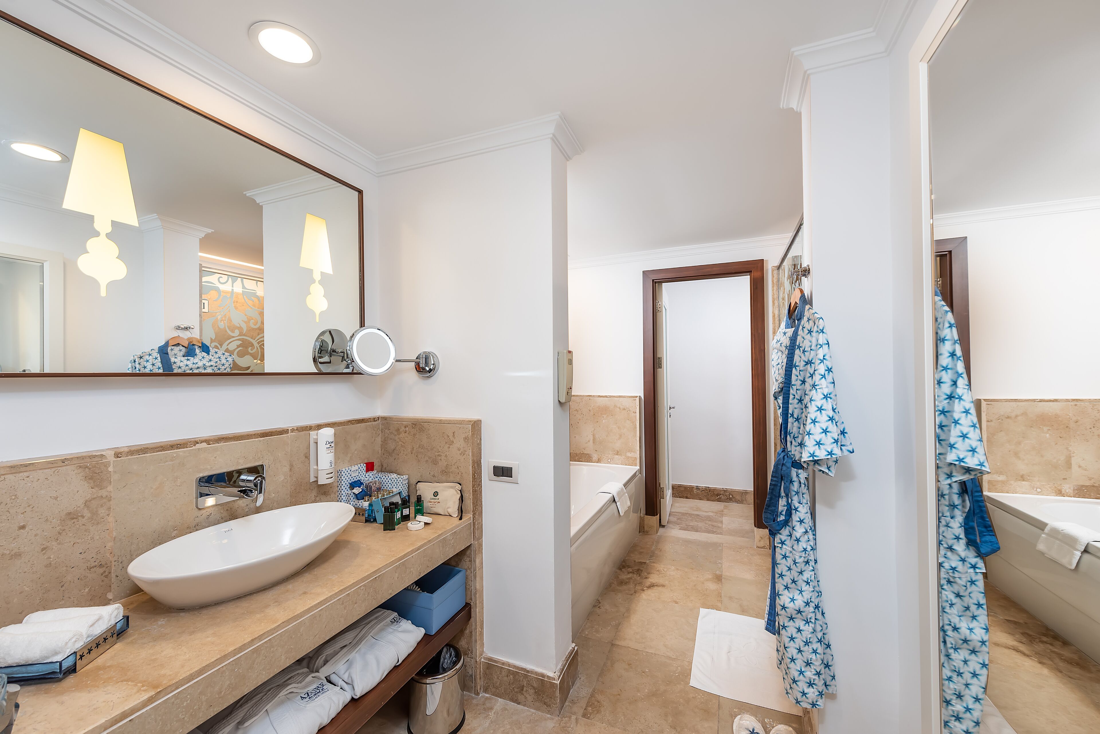 Un baño moderno con un espejo grande, un lavamanos, una bañera y una ducha.
