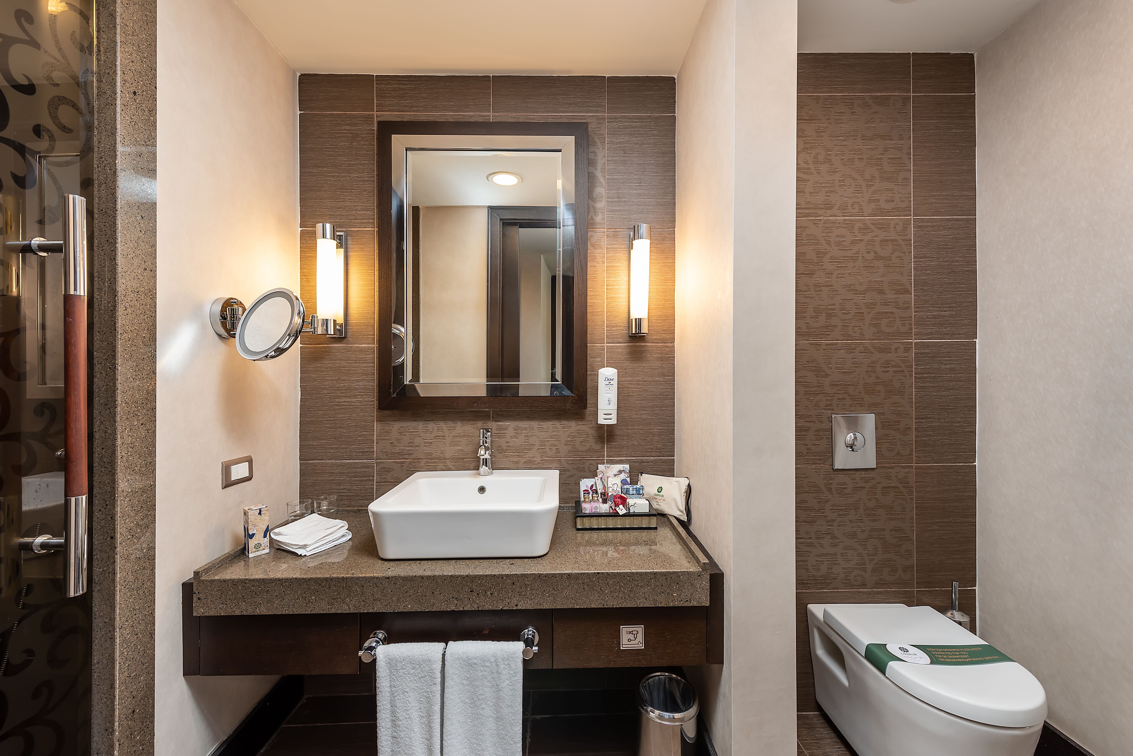 A modern bathroom with a sink, mirror, and toilet.