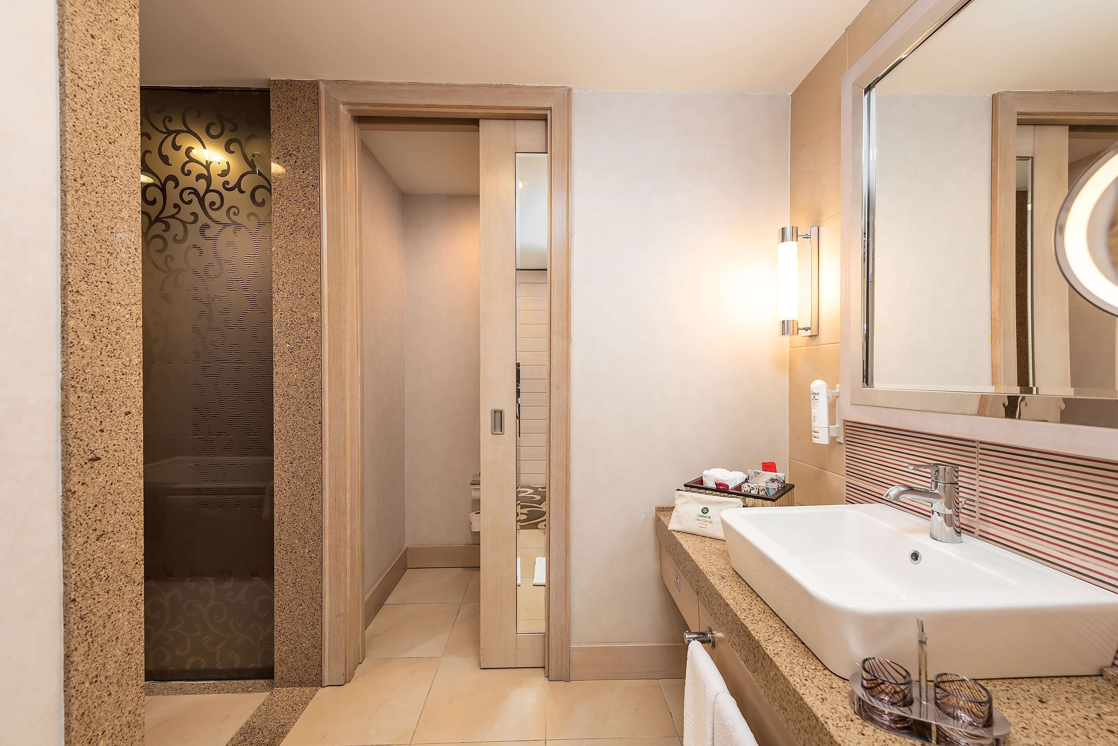 A modern bathroom with a large sink, a mirror, and a shower enclosure.