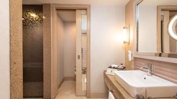 A modern bathroom with a large sink, a mirror, and a shower enclosure.
