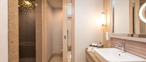 A modern bathroom with a large sink, a mirror, and a shower enclosure.