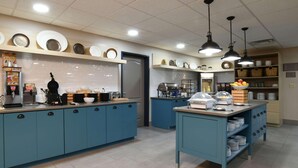 A kitchen with blue cabinets, a coffee station, and various kitchen appliances. - Country Inn & Suites by Radisson, Oklahoma City Airport, OK (Oklahoma City)