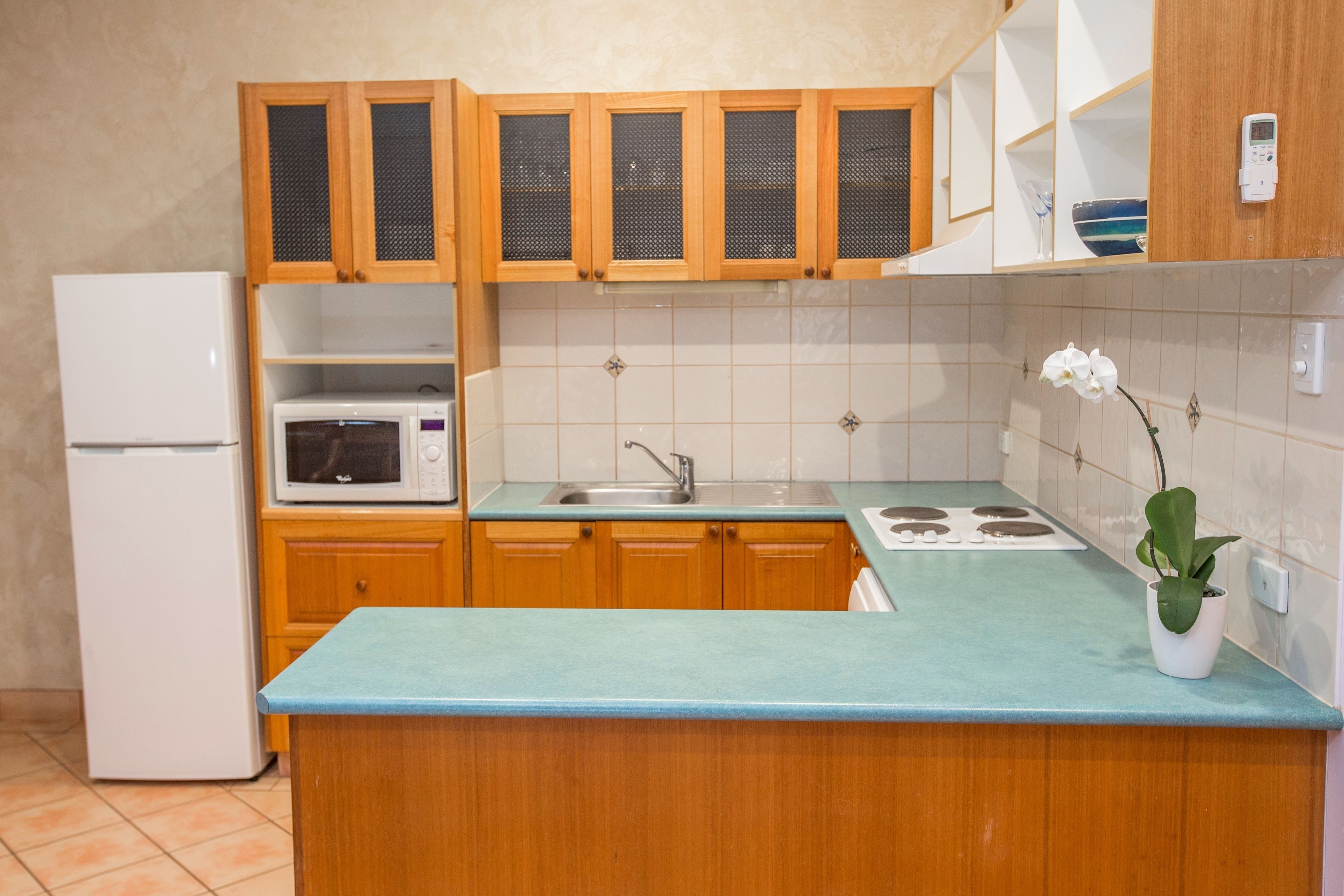 A kitchen with wooden cabinets, a white refrigerator, a microwave, a sink, and a stove.