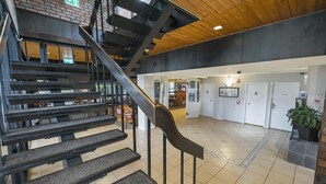 A modern interior with a staircase, a reception area, and a tiled floor.