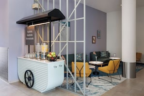 A modern bar area with a white counter, a black overhead structure, and a sign that reads 'Hydrate. Meditate. Re-evaluate.' - Spark by Hilton Essen City Centre (Essen)