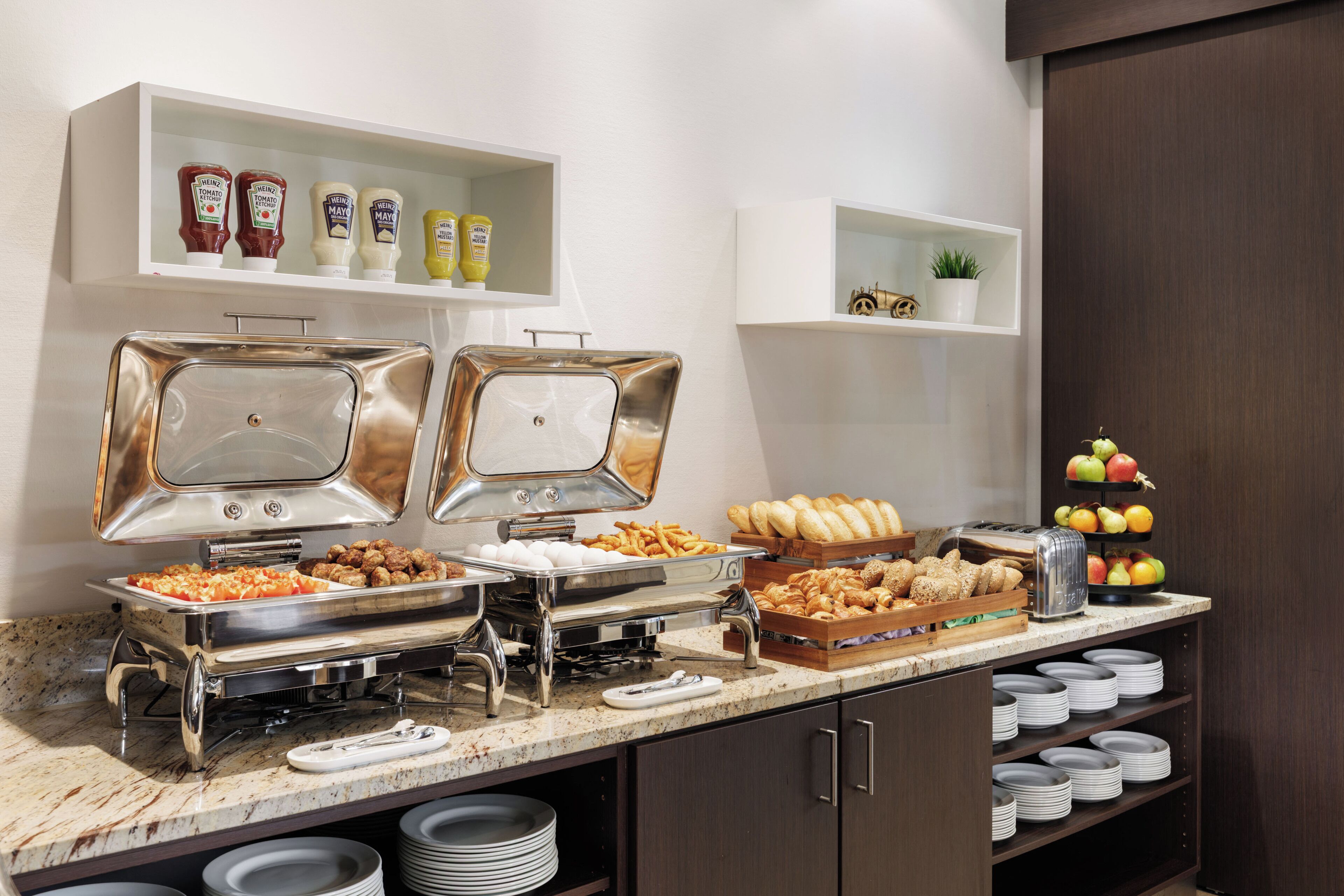 A buffet setup with various food items and condiments.