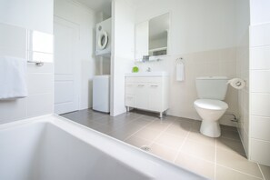 Une salle de bain moderne avec une baignoire, des toilettes et un lavabo.